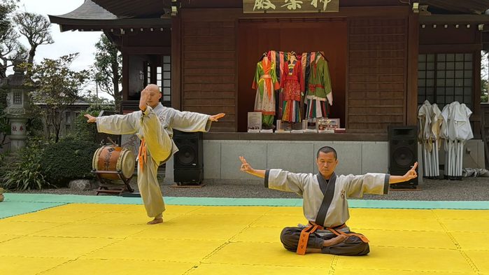 座って両腕を広げる禅武道の演武