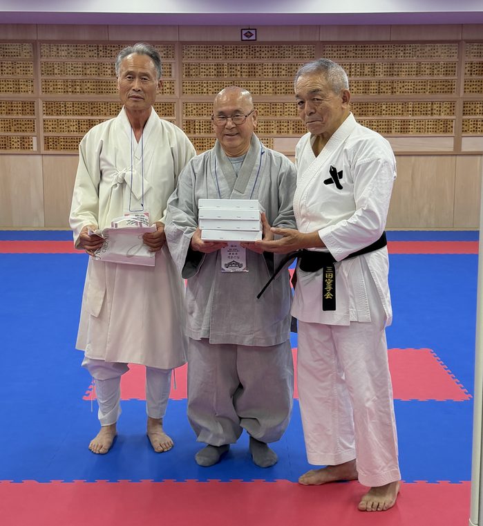 記念品を手に並ぶ3人の記念撮影